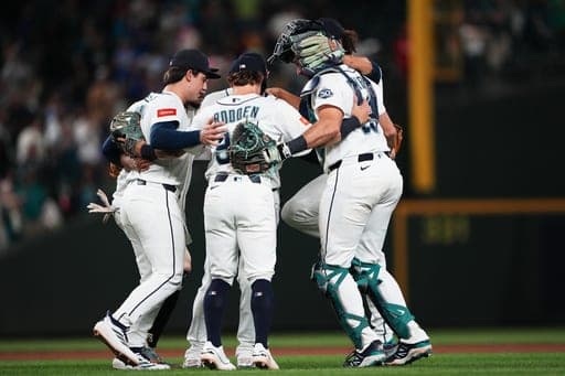 The Seattle Mariners infield, including second baseman Cole Young, shortstop Brock Rodden (90) and catcher Cal Raleigh, right, celebrate a win over the Philadelphia Phillies in a baseball game, Monday, Aug. 24, 2026, in Seattle. (AP Photo/Lindsey Wasson) (AP Photo/Lindsey Wasson)