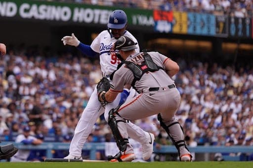 Los Angeles Dodgers' Josue De Paula, left, is tagged out by San Francisco Giants catcher Andrew Knizner as he tries to score after Will Smith hit into a fielder's choice during the seventh inning of a baseball game Sunday, Sept. 20, 2026, in Los Angeles. (AP Photo/Mark J. Terrill) (AP Photo/Mark J. Terrill)
