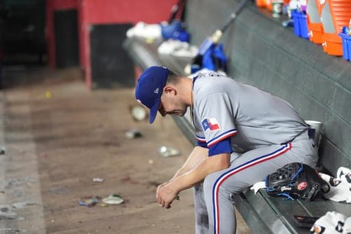 Texas Rangers starting pitcher MacKenzie Gore sits in the dugout during the fifth inning of a baseball game against the Arizona Diamondbacks, Friday, Sept. 11, 2026, in Phoenix. (AP Photo/Ross D. Franklin) (AP Photo/Ross D. Franklin)