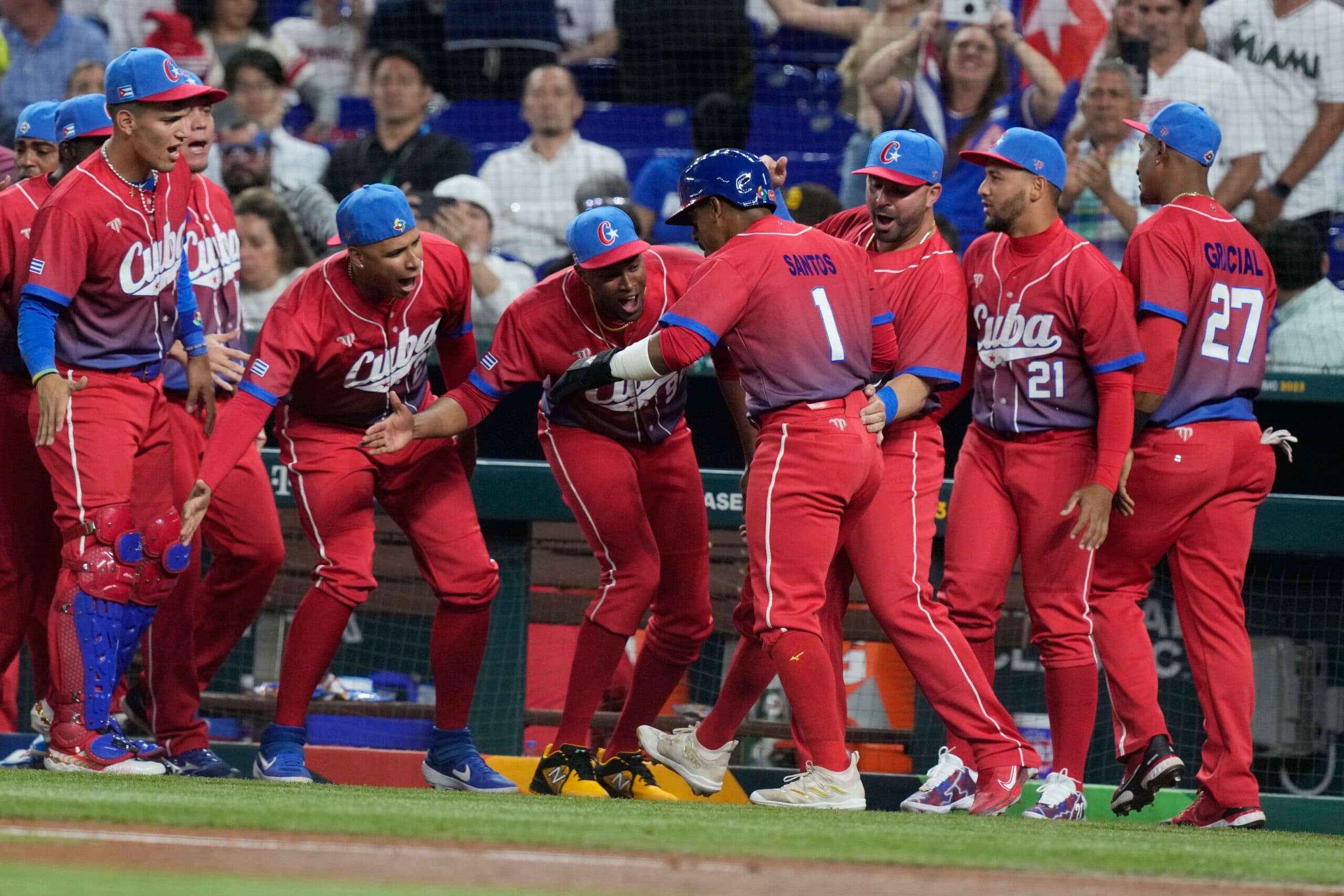 Cuba's Roel Santos (1) is congratulated by his teammates after he scored in the first inning at a World Baseball Classic game against the U.S., Sunday, March 19, 2023, in Miami. (AP Photo/Marta Lavandier)