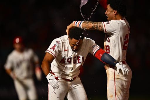 Los Angeles Angels' Christian Moore, center, is greeted by Jose Siri, right, after hitting a walk-off single during the 11th inning of a baseball game against the Minnesota Twins, Saturday, Sept. 19, 2026, in Anaheim, Calif. (AP Photo/William Liang) (AP Photo/William Liang)