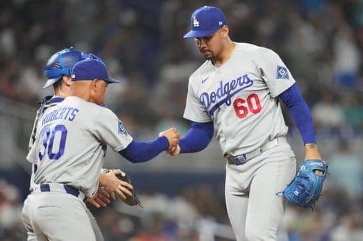 Los Angeles Dodgers pitcher Edgardo Henriquez (60) hands the ball to manager Dave Roberts (30) as he is relieved during the eighth inning of a baseball game against the Miami Marlins, Sunday, Sept. 13, 2026, in Miami. (AP Photo/Lynne Sladky) (AP Photo/Lynne Sladky)