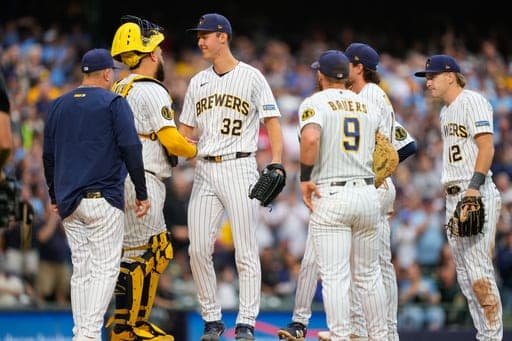 El lanzador de los Cerveceros de Milwaukee, Jacob Misiorowski (32), estrecha la mano del receptor Gary Sánchez —segundo desde la izquierda— durante un cambio de lanzador en la sexta entrada de un partido de béisbol contra los Cardenales de San Luis, el domingo 27 de septiembre de 2026, en Milwaukee. (Foto AP/Kayla Wolf) (AP Photo/Kayla Wolf)