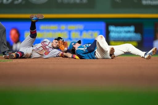 Atlanta Braves' Mauricio Dubón, left, reaches for second base after being tagged out by Milwaukee Brewers second baseman Brice Turang, right, during the seventh inning of a baseball game Friday, Aug. 21, 2026, in Milwaukee. (AP Photo/Kayla Wolf) (AP Photo/Kayla Wolf)