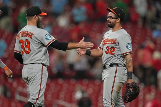 Baltimore Orioles' Christian Encarnacion-Strand (32) and Andrew Kittredge (39) celebrate a victory over the St. Louis Cardinals following a baseball game Wednesday, Aug. 26, 2026, in St. Louis. (AP Photo/Jeff Roberson) (AP Photo/Jeff Roberson)