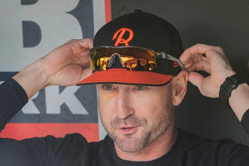 Orioles manager playfully puts on a mask in the dugout to protect himself from foul balls
