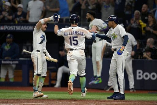 Tampa Bay Rays' Ben Williamson (15) is congratulated by Taylor Walls, left, and Chandler Simpson, right, after scoring during the fourth inning in Game 2 of an American League Championship Series baseball game against the Cleveland Guardians, Tuesday, Oct. 13, 2026, in St. Petersburg, Fla. (AP Photo/Phelan M. Ebenhack) (AP Photo/Phelan M. Ebenhack)