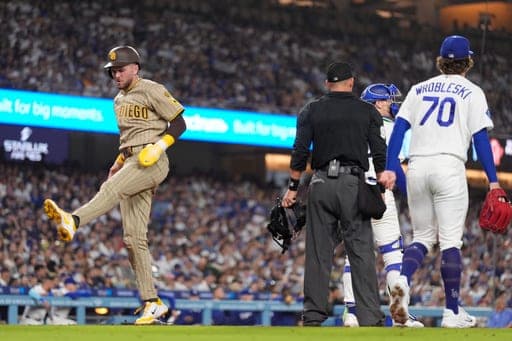 San Diego Padres' Jackson Merrill, left, scores on a single by Austin Hays as Los Angeles Dodgers catcher Hunter Feduccia, second from right, and pitcher Justin Wrobleski stand by during the seventh inning of a baseball game Thursday, Sept. 24, 2026, in Los Angeles. (AP Photo/Mark J. Terrill) (AP Photo/Mark J. Terrill)