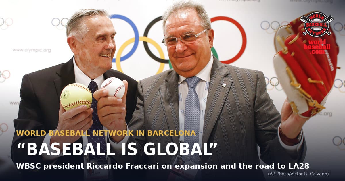 International Baseball Federation president Riccardo Fraccari, right, holds a red baseball glove beside International Softball Federation president Don Porter, who holds a softball and a baseball, at a news conference in Buenos Aires on Sept. 6, 2013.
