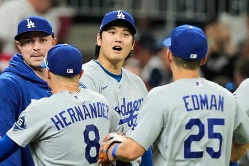 Los Angeles Dodgers' Shohei Ohtani, center, Enrique Hernández (8) and Tommy Edman (25) celebrate the team's win in Game 3 of baseball's National League Division Series against the Atlanta Braves, Tuesday, Oct. 6, 2026, in Atlanta. (AP Photo/Brynn Anderson) (AP Photo/Brynn Anderson)