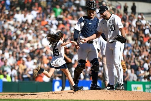 Genevieve Verlander, left, runs to hug her dad, Detroit Tigers starting pitcher Justin Verlander, right, as catcher Dillon Dingler looks on during the sixth inning of a baseball game against the Pittsburgh Pirates, Saturday, Sept. 26, 2026, in Detroit. (AP Photo/Jose Juarez) (AP Photo/Jose Juarez)