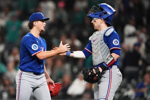 Texas Rangers relief pitcher Adam Macko, left, greets catcher Danny Jansen, right, to celebrate a win over the Seattle Mariners of a baseball game, Tuesday, Sept. 8, 2026, in Seattle. (AP Photo/Lindsey Wasson) (AP Photo/Lindsey Wasson)
