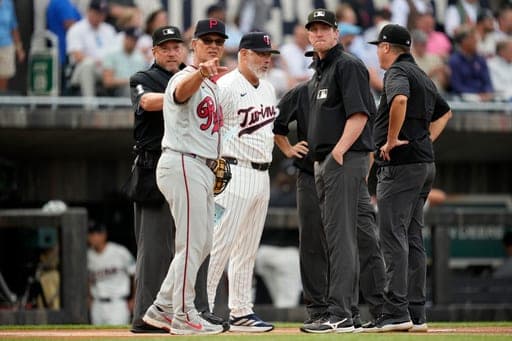 Philadelphia Phillies interim manager Don Mattingly, left, talks with umpires before a baseball game against the Minnesota Twins at the Field of Dreams movie site, Thursday, Aug. 13, 2026, in Dyersville, Iowa. (AP Photo/Charlie Neibergall) (AP Photo/Charlie Neibergall)