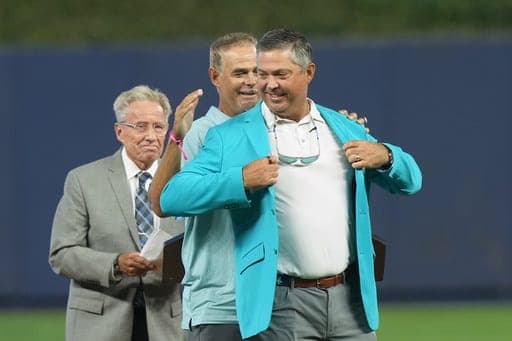 Former Miami Marlins Mike Lowell puts on the team's hall of fame jacket on former pitcher Josh Beckett during a ceremony before a game against the Chicago Cubs Sunday, Sept. 6, 2026, in Miami. (AP Photo/Marta Lavandier) (AP Photo/Marta Lavandier)