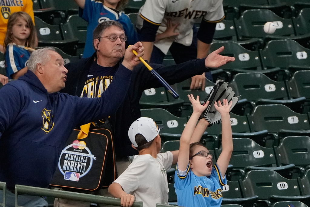 Fans reach for a ball before Game 1 of the National League Division Series in Milwaukee.