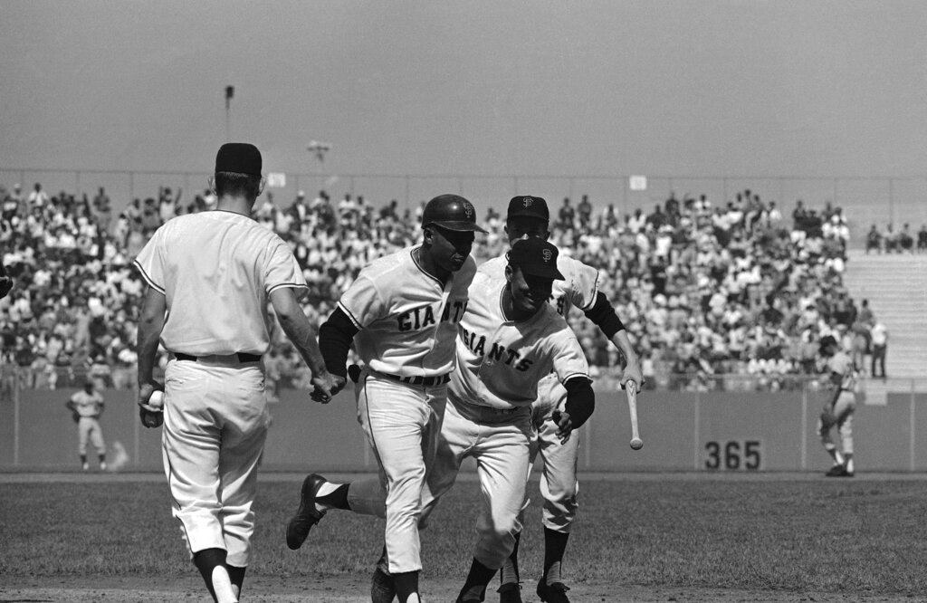 A young Felipe Alou celebrates with Giants teammate Willie Mays after a home run in 1962.