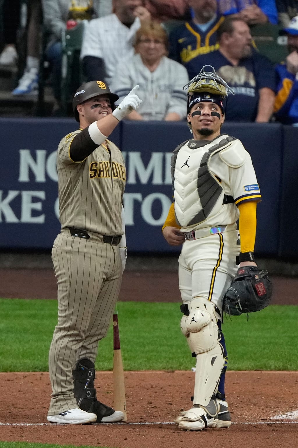 Padres first baseman Ty France talks with Brewers catcher William Contreras about the ball that hit a roof cable in Game 1.