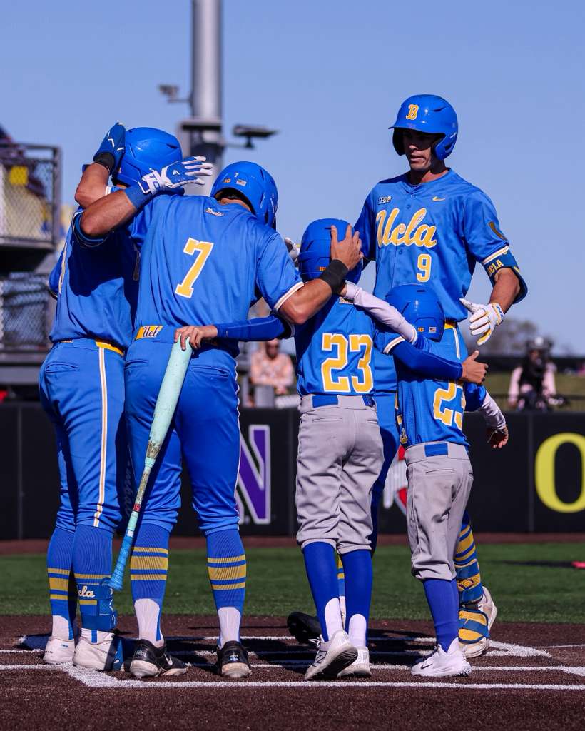UCLA baseball team celebrating at home plate vs Rutgers