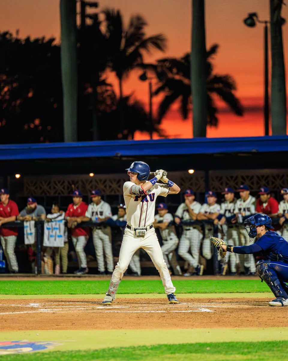 FAU’s Marshall Lipsey batting against Bucknell with a sunset-lit sky in the background.