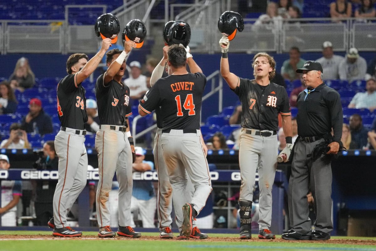 Daniel Cuvet of the Miami Hurricanes celebrates with teammates after hitting a grand slam against FIU Panthers in a 7-3 win at loanDepot Park.