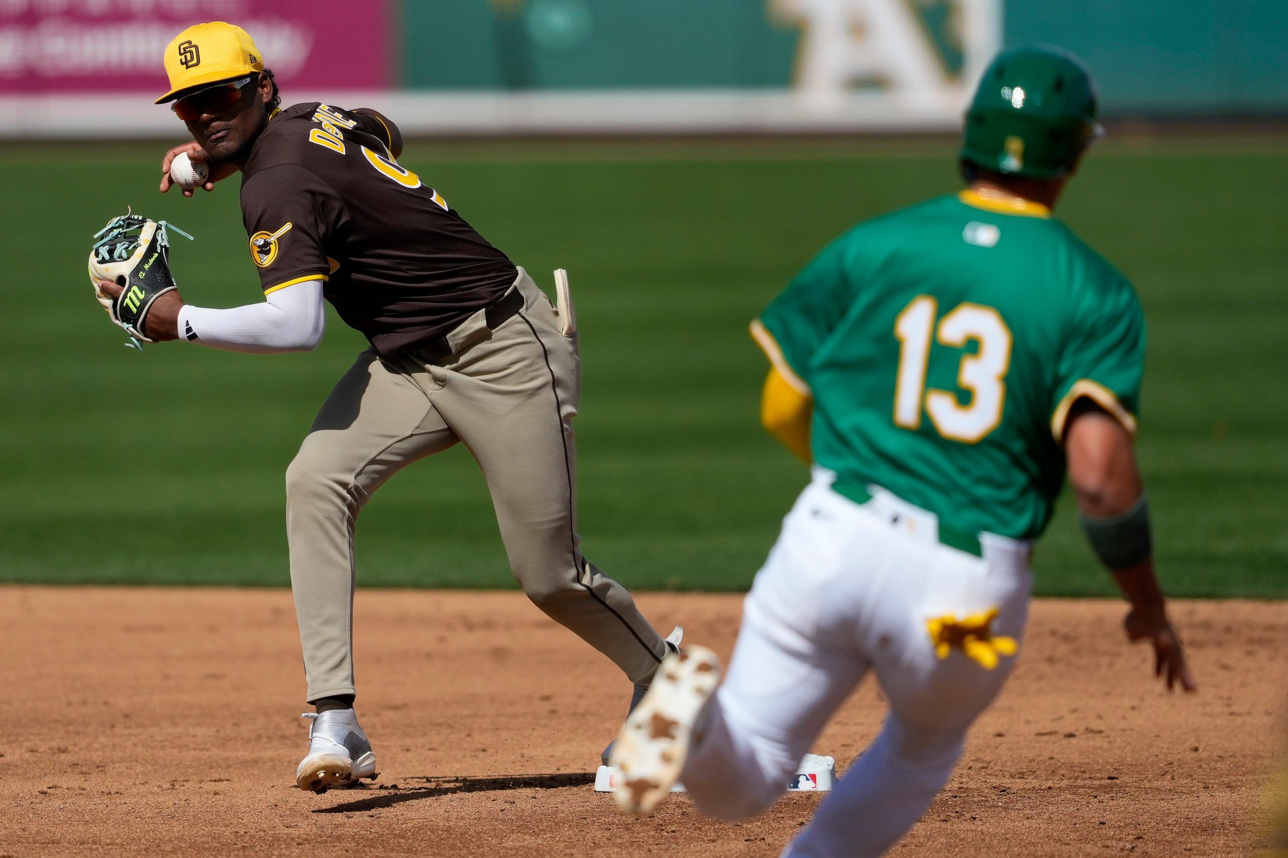 Padres Athletics Spring Baseball Image ID : 25058844343608 San Diego Padres' Leodalis De Vries forces out Athletics' Gio Urshela (13) as he turns a double play on CJ Alexander during the second inning of a spring training baseball game, Thursday, Feb. 27, 2025, in Mesa, Ariz. (AP Photo/Matt York)