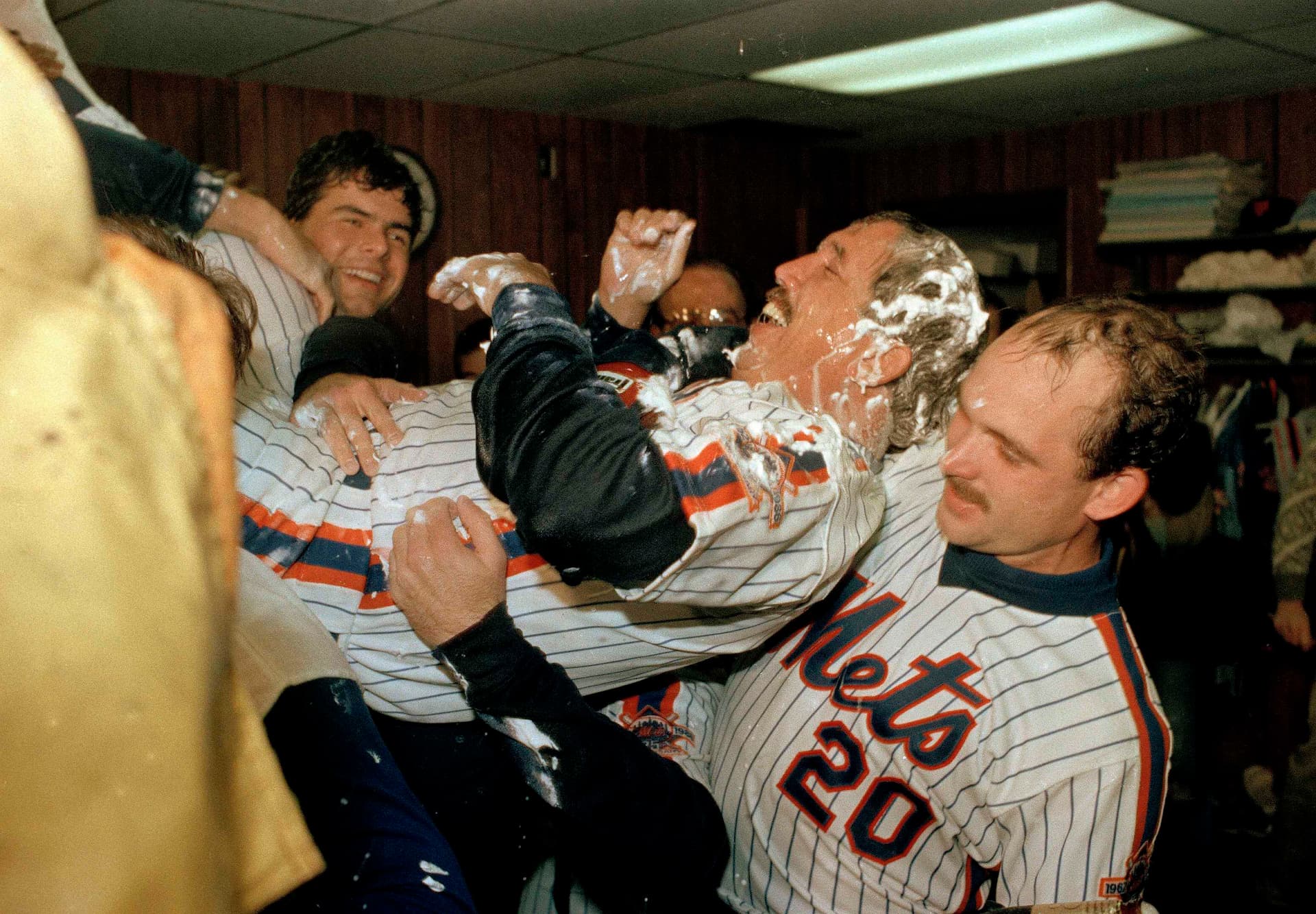 New York Mets Manager Davey Johnson is carried to the shower by Howard Johnson,