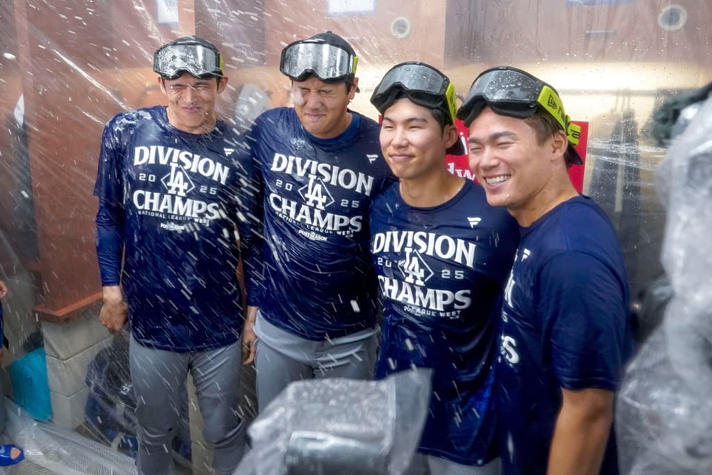 AP25268835966912 1 - World Baseball Network Title: Dodgers Diamondbacks BaseballImage ID: 25268835966912 Article: Los Angeles Dodgers Roki Sasaki, left, Shohei Ohtani, left center, H.S. Kim, right center and Yoshinobu Yamamoto, right, celebrate after the Dodgers clinched the National League West title against the Arizona Diamondbacks during a baseball game at Chase Field Thursday, Sept. 25, 2025, in Phoenix. (AP Photo/Darryl Webb)