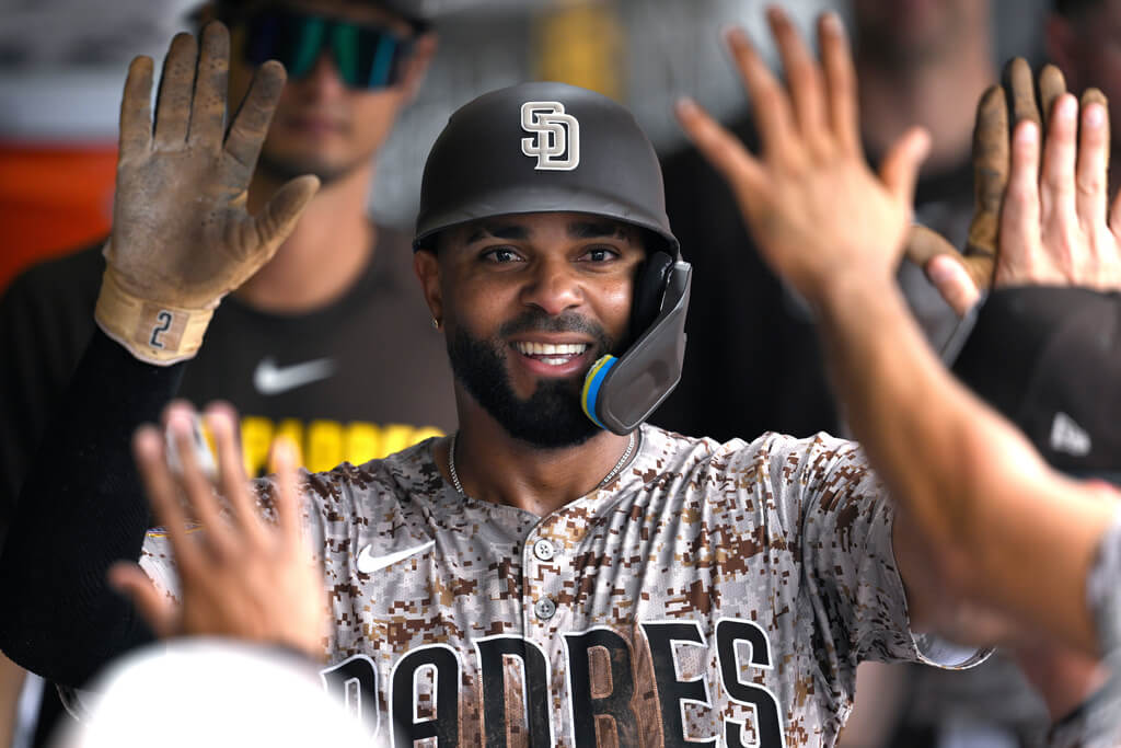 San Diego Padres' Xander Bogaerts is congratulated in the dugout after scoring on sacrifice fly by Jake Cronenworth during the first inning of a baseball game against the Arizona Diamondbacks, Sunday, Sept. 28, 2025, in San Diego. (AP Photo/Orlando Ramirez)