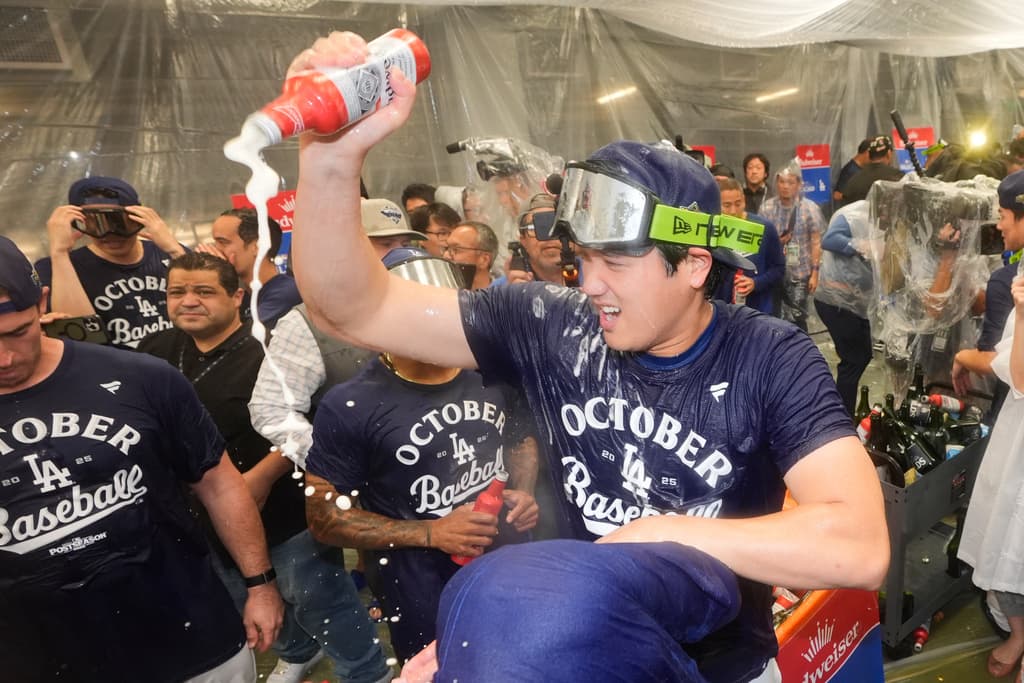 Title: Reds Dodgers BaseballImage ID: 25275168327072 Article: Los Angeles Dodgers' Shohei Ohtani, right, celebrates in the clubhouse after a win over the Cincinnati Reds in Game 2 of the National League Wild Card baseball playoff series Wednesday, Oct. 1, 2025, in Los Angeles. (AP Photo/Mark J. Terrill) 