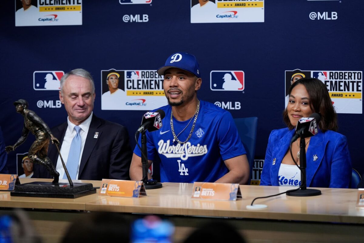 Mookie Betts Wins 2025 Roberto Clemente Award As Dodgers Outlast Blue Jays In 18-Inning Game 3 - World Baseball Network Title: World Series Blue Jays Dodgers Baseball Image ID: 25300818929151 Article: Los Angeles Dodgers' Mookie Betts speaks after receiving the Roberto Clemente Award as wife Brianna Betts, right, and MLB Commissioner Rob Manfred, left, listen prior to Game 3 of baseball's World Series against the Toronto Blue Jays, Monday, Oct. 27, 2025, in Los Angeles. (AP Photo/Ashley Landis)