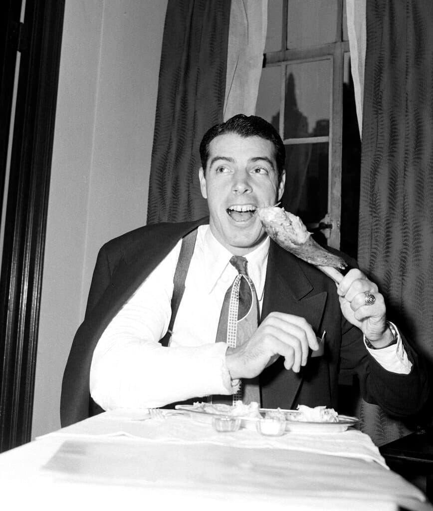 Title: Yankees DiMaggio Thanksgiving 1947Image ID: 471127047
Article:  His right arm encased in a cast after a recent operation, Joe DiMaggio turns southpaw to take his turn at the plate for his Thanksgiving dinner in New York, Nov. 27, 1947. The Baseball Writers Association of America voted Joe the Most Valuable Player in the American League this year for the third time, the honor having been conferred on him previously in 1939 and 1941. (AP Photo/John Lindsay)
