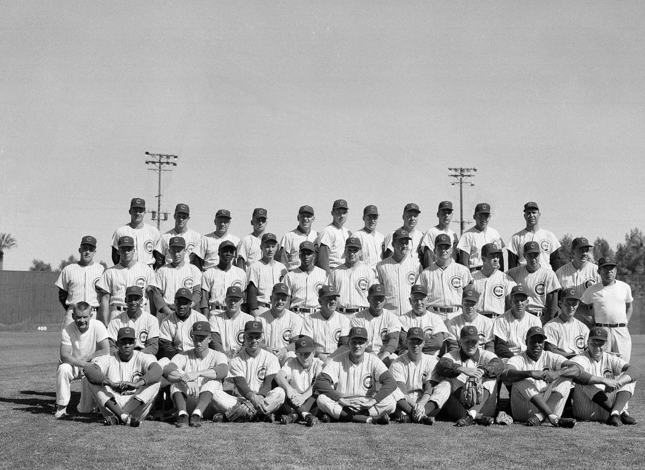 Title: Chicago Cubs 1960 Image ID: 6003160113 Article: The Chicago Cubs are shown at their Mesa, Arizona spring training camp, March 15, 1960. Front row, left to right: Billy Williams, Glen Hobbie, Jerry Kindall, Jerry Martin, Ben Johnson, Don Elston, Bob Anderson, George Altman, Moe Drabowski. Second row: Al Scheuneman, Ernie Banks, Tony Taylor, Bob Will, Elvin Tappe, Charlie Grimm, Lou Klein, Charley Root, Richie Ashburn, Del Rice, and Sammy Taylor. Third row: Moe Morhardt, Dick Drott, Ron Santo, Lou Johnson, Ken Hubbs, Sam Drake, Art Ceccarelli, Dale Long, Seth Morehead, Earl Averill, Harry Bright, Irv Noren, and Yosh Kawano. Back row: Nelson Mathews, Cal Neeman, Steve Ridzik, Dick Burwell, Walt Moryn, Joe Schaffernoth, Joe Schaffernoth, Moe Thacker, Art Schuit, Dick Ellsworth, Frank Thomas, and Dick Gernert. (AP Photo/Harold Filan)