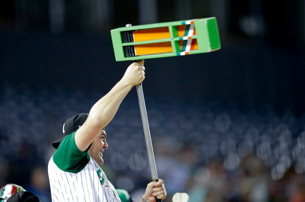 Title: Panama Caribbean Series Baseball Image ID: 19039007978268 Article: A fan of Mexico's Los Charros de Jaliscos, cranks a giant noise maker as he cheers for his team during a baseball game against Cuba's Los Leneros de las Tunas, during a match of the Caribbean Series baseball tournament at Rod Carew stadium in Panama City, Thursday, Feb. 7, 2019. (AP Photo/Arnulfo Franco)