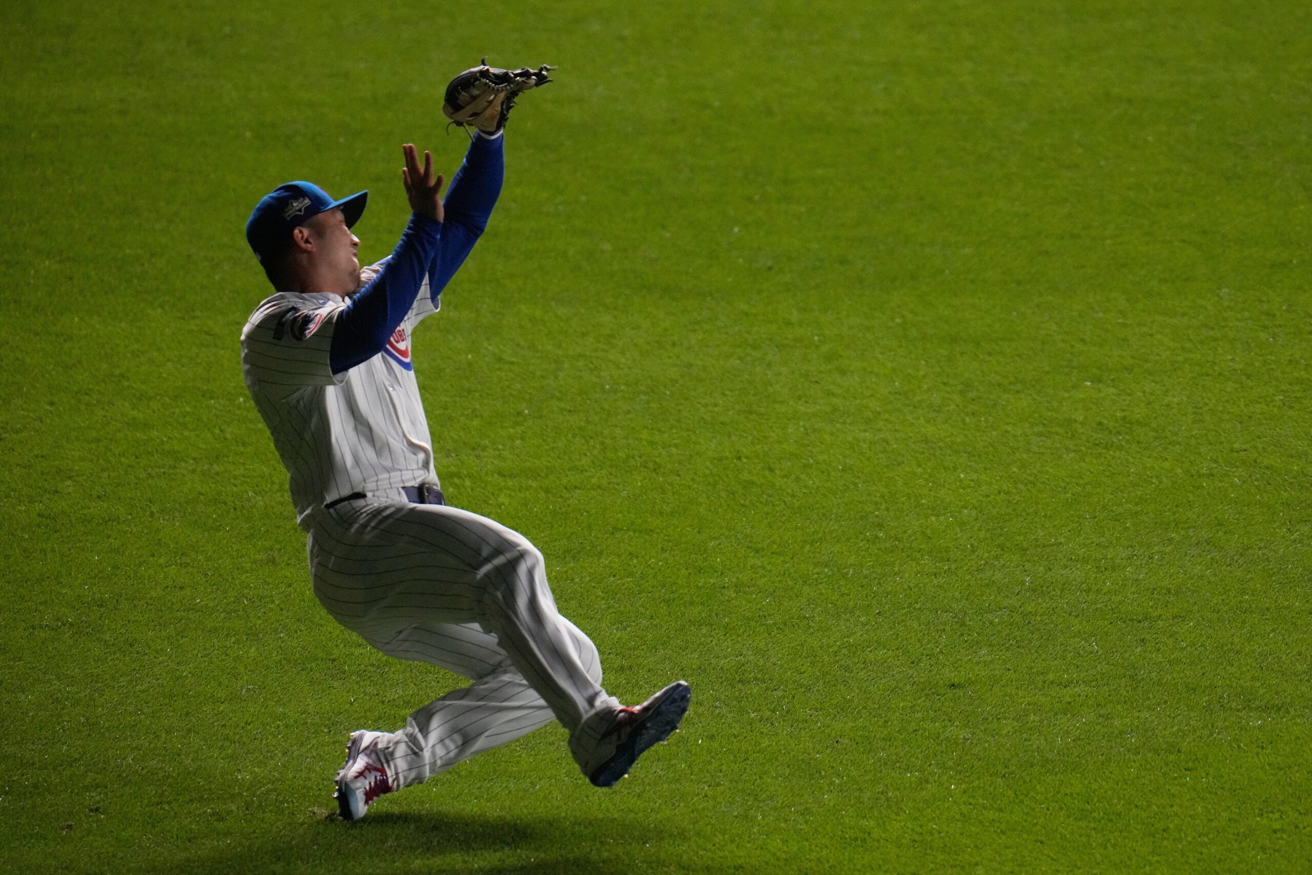 Chicago Cubs right fielder Seiya Suzuki (27) makes a sliding catch to out Milwaukee Brewers' Joey Ortiz (3) to end the top of the seventh inning of Game 4 of baseball's National League Division Series Thursday, Oct. 9, 2025, in Chicago. (AP Photo/Erin Hooley)