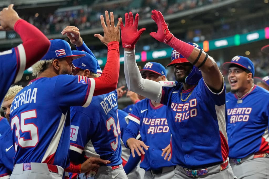 Puerto Rico's Willi Castro, right, is congratulated by teammates after hitting a solo home run during the first inning of a World Baseball Classic quarterfinal game against Italy, Saturday, March 14, 2026, in Houston. (AP Photo/Karen Warren)